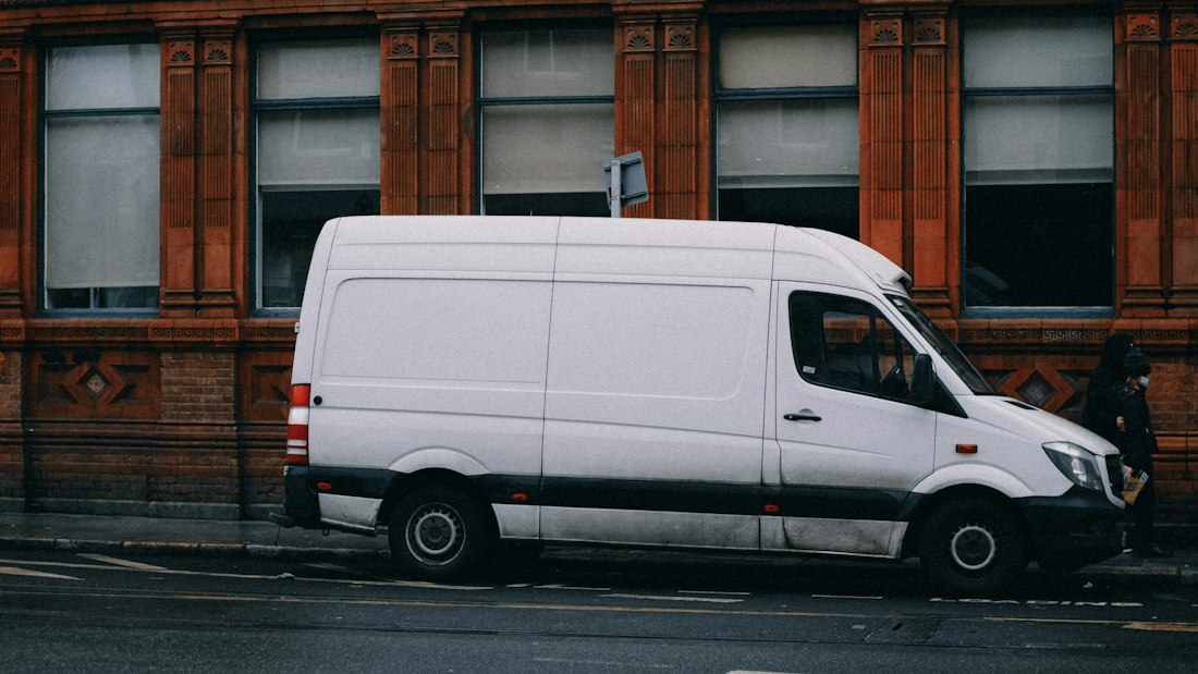 A white service van parked at the roadside