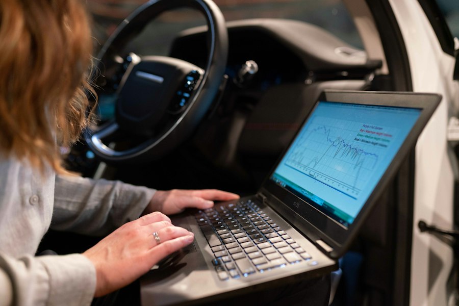 Technician reading live engine data on a laptop inside a car