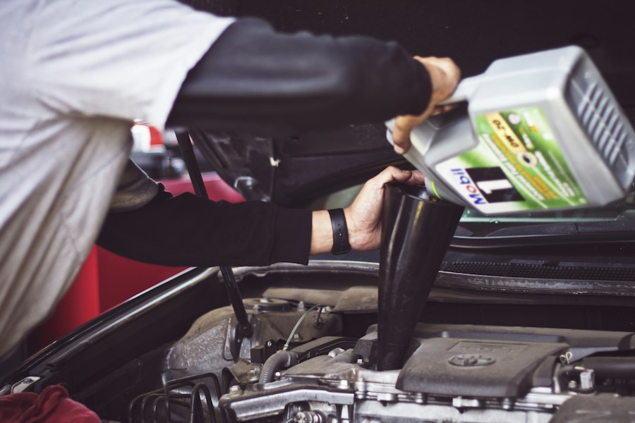 Mechanic refilling motor oil in an engine bay