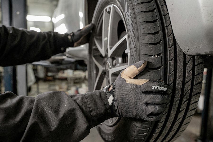 Gloved hands fitting a tire to a vehicle